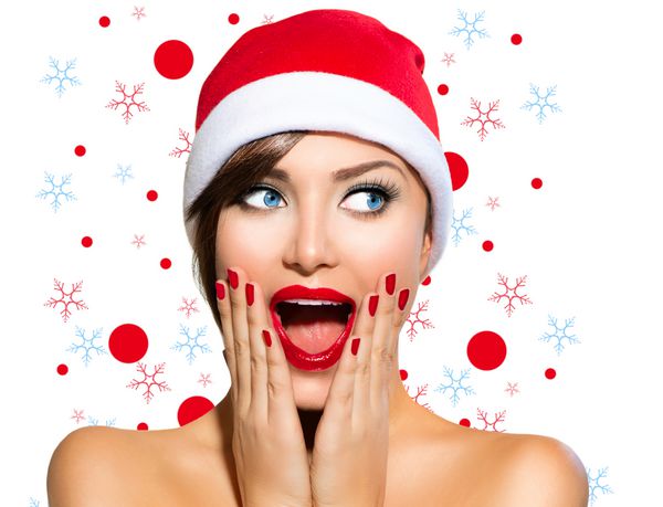 زن کریسمس دختر مدل زیبایی در سانتا کلاه جدا شده در زمینه سفید خنده دار خنده دار پرتره زن دهان باز احساسات واقعی لب و مانیکور قرمز آرایش تعطیلات زیبا