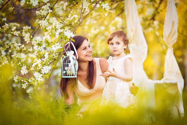 زن و کودک مبارک در باغ بهار شکوفه زن بوسیدن کودک مفهوم تعطیلات روز مادران