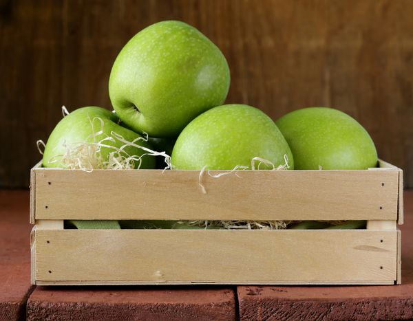 سیب های سبز مادربزرگ اسمیت در یک جعبه چوبی
