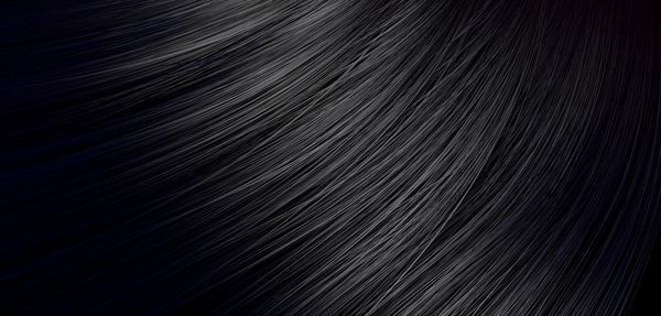 نمای نزدیک از یک دسته از موهای سیاه براق مستقیم و به سبک خمیده موج دار