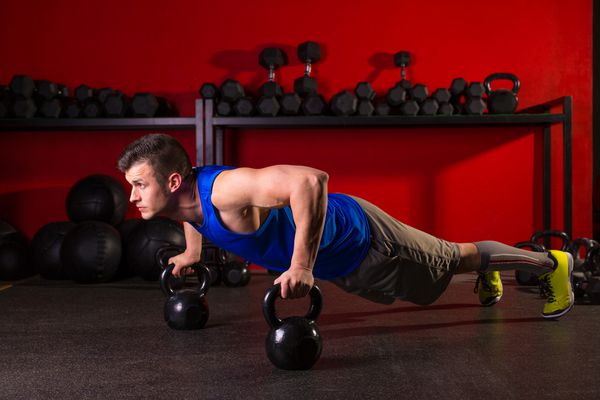 Kettlebells تمرین مردانه با فشار قوی مردان در ورزشگاه