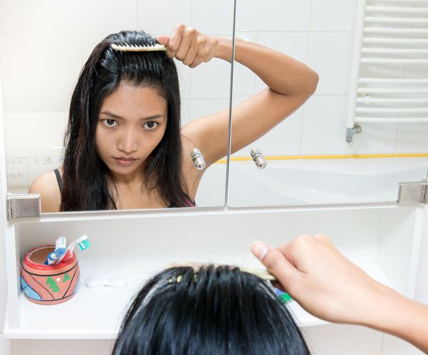 دختر موهای خود را در حمام شانه می کند