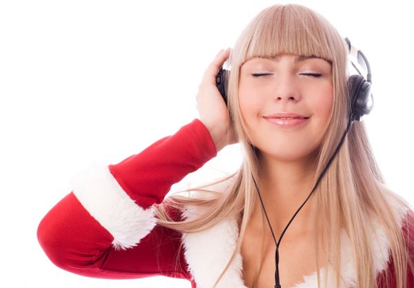 دختر زیبا که به عنوان سانتا در حال گوش دادن به موسیقی لباس می پوشید