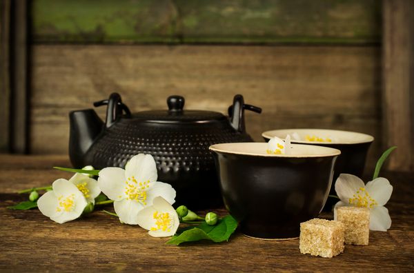 مجموعه چای آسیایی با گل یاس در زمینه چوبی