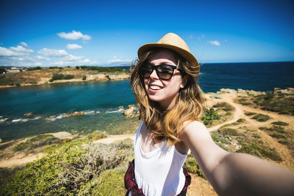 توریست زن جوان و جوان هنگام تعطیلات تابستانی در جزیره کرت در یونان سلفی سفر می کند