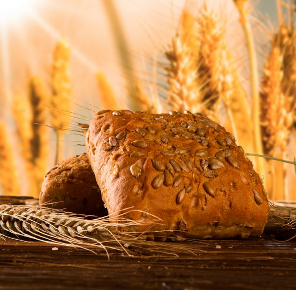 نان را روی میز چوبی با زمینه ذرت و طبیعت قرار دهید