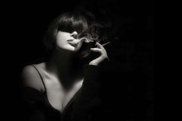 زن جوان شیک با حاشیه مرسوم مد روز سیگار می کشید مدل موهای کوتاه پرتره مد بالا به رنگ سیاه و سفید با فضای کپی متن