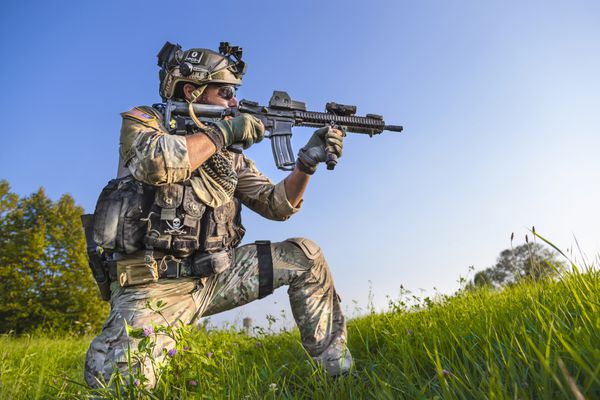پرتره سرباز آمریکایی که هدفش از اسلحه اش در پس زمینه آسمان آبی است