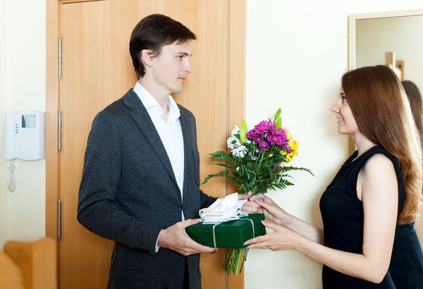 لبخندی به مرد دادن گل و هدیه به زن در خانه