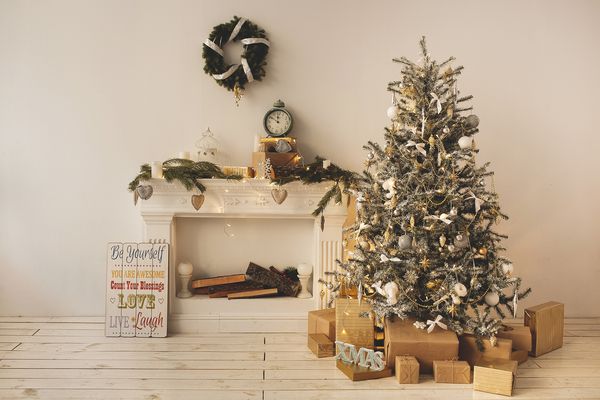 اتاق تزئین شده زیبا با درخت کریسمس تزئین شده با جعبه های موجود در زیر آن