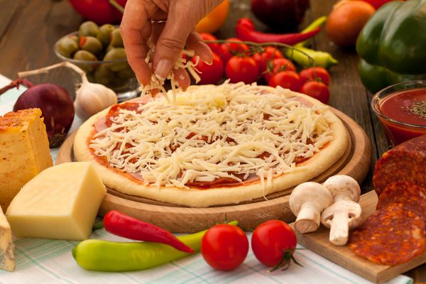 پنیر رنده شده را در بالای پیتزا قرار دهید