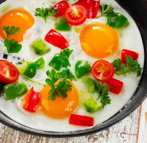 تخم مرغ های سرخ شده را در یک تابه با سبزیجات سرخ کنید تمرکز انتخابی