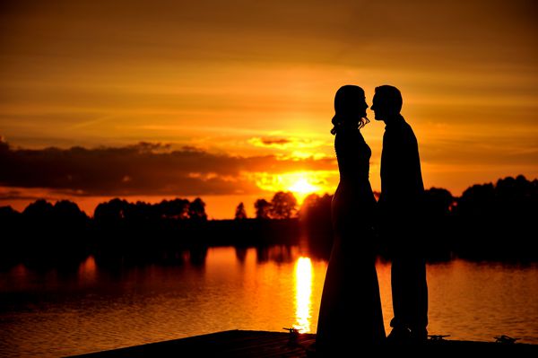 شبح های دو عاشق که در پس زمینه عصر در کنار دریاچه می بوسیدند لحظه ای عاشقانه آرام