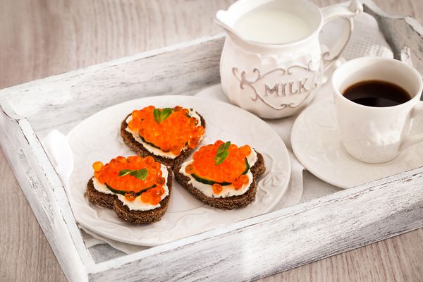 صبحانه رمانتیک با نان تست های قلب با خاویار قرمز و قهوه مفهوم