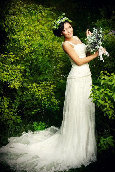 عروس زیبا و زیبا آسیایی در یک پارک تابستانی لباس عروسی و لوازم جانبی
