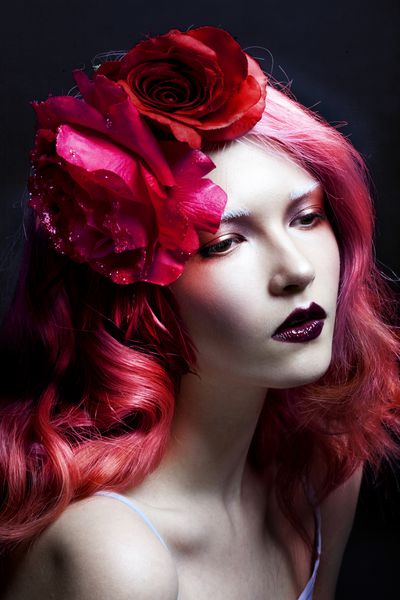 دختر زیبا با موهای صورتی گل بزرگ گل رز در موهایش