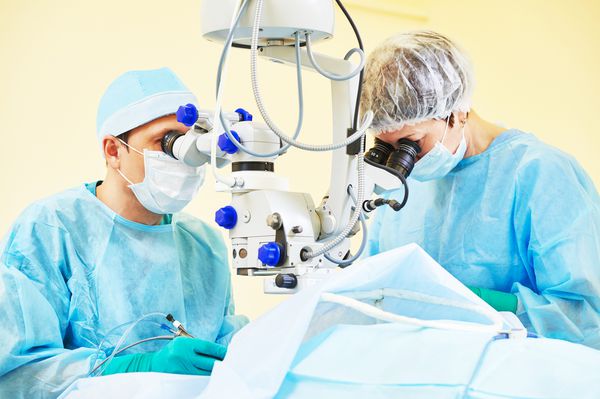 تیم جراح با لباس فرم مقابل اتاق عمل جراحی بینایی چشم در کلینیک پزشکی