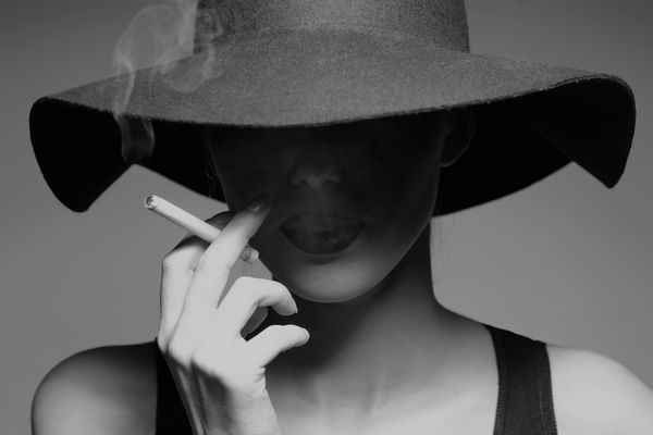 سیگار کشیدن زن در کلاه سیاه