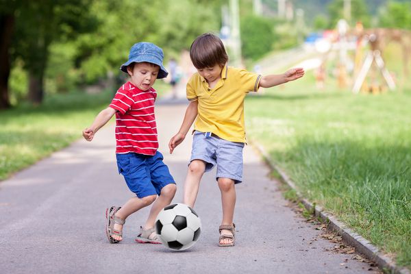 دو بچه کوچک ناز فوتبال با هم تابستان فوتبال کودکان در فضای باز