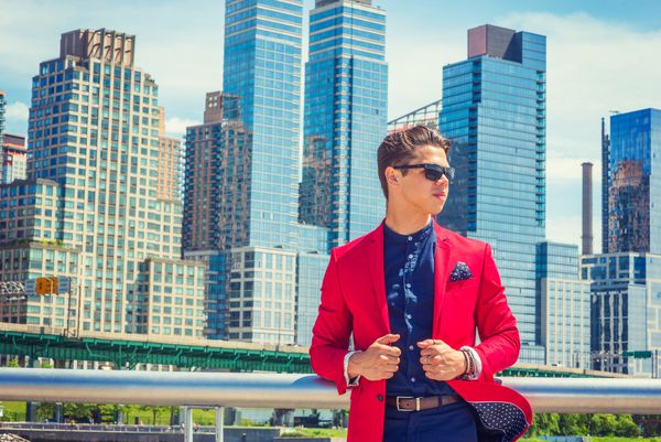 تاجر مسافرتی کار در نیویورک پیراهن کتانی قرمز پیراهن بدون پیراهن آبی پوشیدن عینک آفتابی مردی که در منطقه تجاری با ساختمان های بلند ایستاده است با اطمینان به انتظار می رود