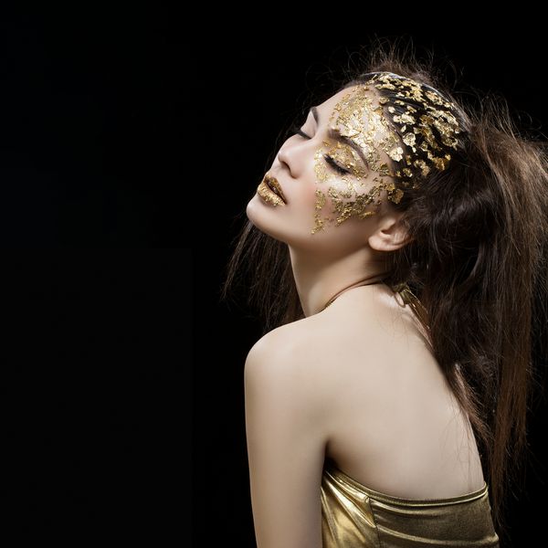 زن جوان و جوان با آرایش فویل طلایی هنر روی صورت و لب ها ترکیب مربع فضا را کپی کنید بیش از زمینه سیاه
