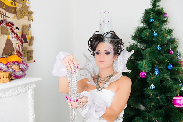 کریسمس مدل مد زمستانی کریسمس با تاج شیشه ای تزئین شده با مدل مو آرایش زن زیبایی تعطیلات زیبای تعطیلات سال نو سبک مو خلاق ملکه برفی