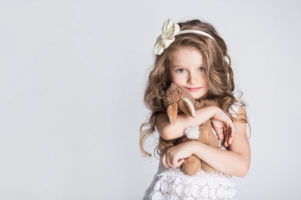 دختر کوچولو زیبا خرگوش اسباب بازی خود را در آغوش می گیرد