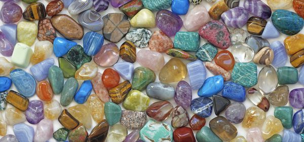پس زمینه سنگهای کریستالی چند رنگی مقدار زیادی از سنگهای قیمتی شفابخش با رنگ های مختلف که زمینه ای برای استفاده به عنوان پس زمینه را تشکیل می دهند