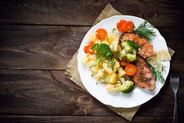 استیک ماهی کباب شده با سبزیجات خرد شده است نمای بالا سبک روستایی
