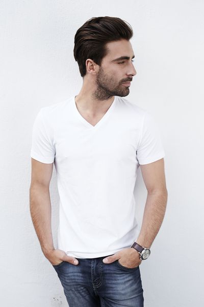 مرد جوان در تی شرت سفید مقابل دیوار سفید
