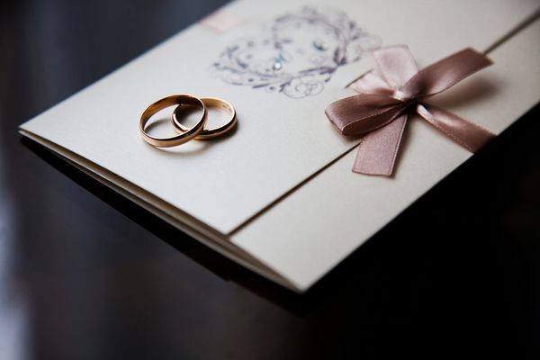 حلقه های عروسی روی کارت دعوت حلقه هایی با پس زمینه تیره آماده سازی عروسی تزیینات عروسی