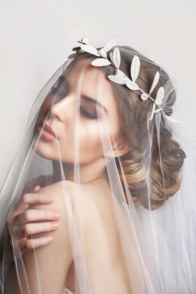 عروس زیبا با مدل موهای عروسی مد بر روی زمینه سفید پرتره تمیز عروس جوان زرق و برق دار عروسی استودیوی شات پرتره عروس زیبا با حجاب بر چهره اش
