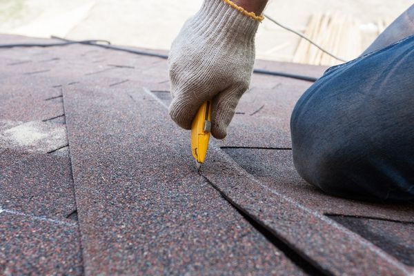 کارگر Roofer زونا را بر روی پشت بام قطع می کند