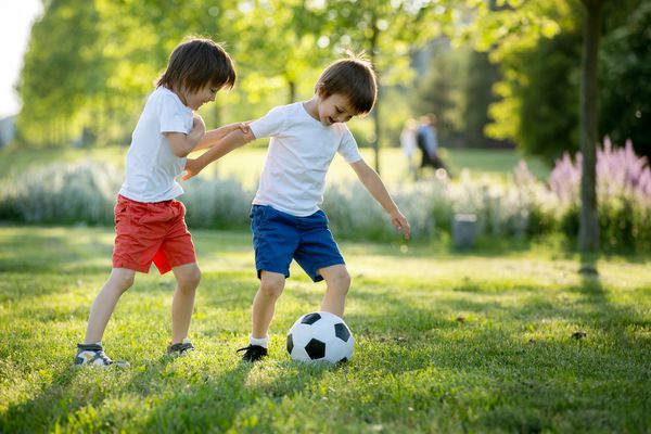 دو بچه کوچک ناز فوتبال با هم تابستان فوتبال کودکان در فضای باز