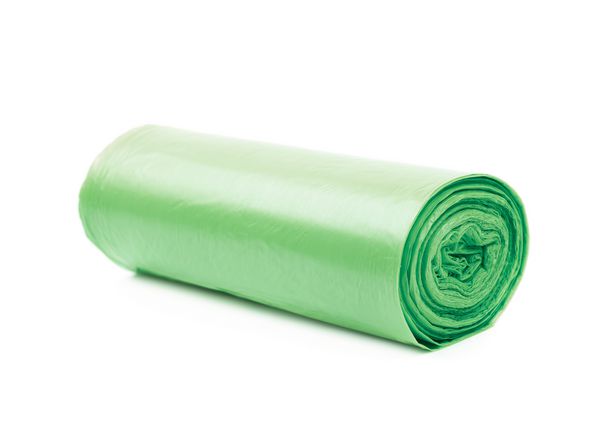 رول پلاستیکی کیسه زباله پلی اتیلن سبز که بر روی زمینه سفید جدا شده است