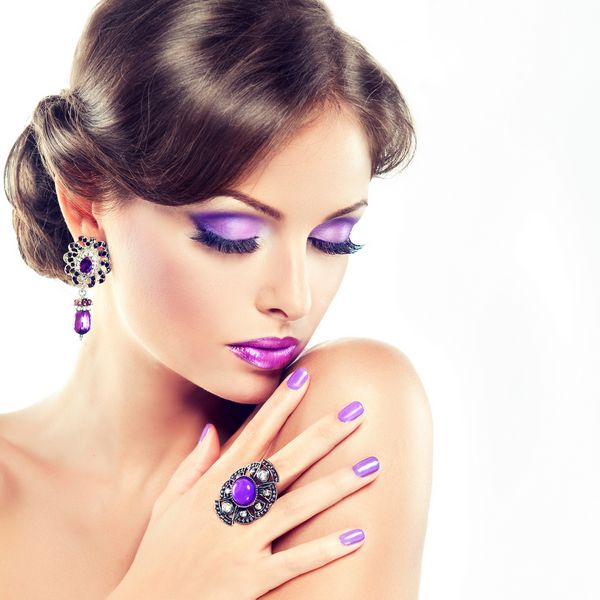 دختر مدل با آرایش یاس بنفش و مانیکور روی ناخن ها جواهرات زنانه با سنگ های بنفش و مدل موهای زیبا