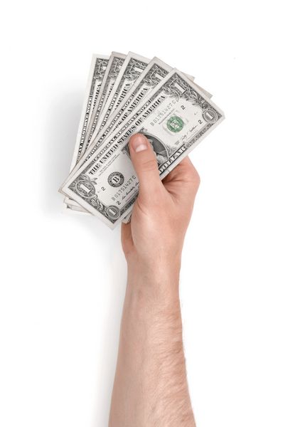 نمای نزدیک از دست یک مرد و صورتحساب یک دلار جدا شده در زمینه سفید پول و ارز پرداخت و خرید