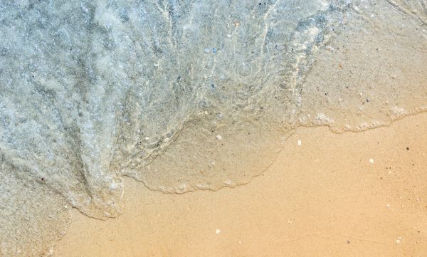 موج دریا از آبی در ساحل شنی نمای بالا