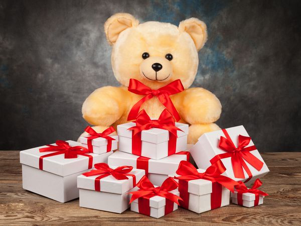 خرس عروسکی و جعبه های سفید با هدیه در تخته قدیمی