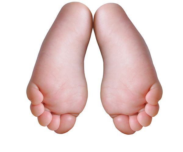 جفت پای کودک کوچک روی شکم جدا شده بر روی زمینه سفید قرار دارد