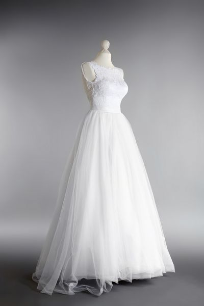 لباس عروسی ساخته شده روی مانکن در برابر پس زمینه خاکستری