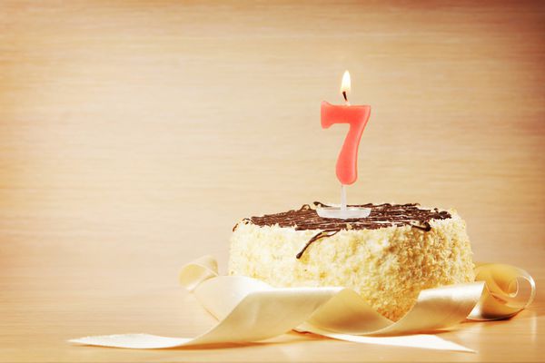 کیک تولد با سوزاندن شمع به عنوان شماره هفت روی شمع تمرکز کنید