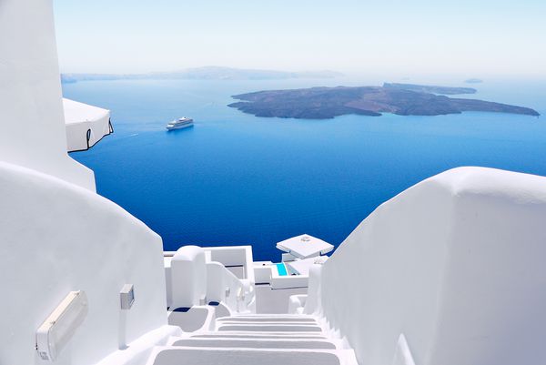 راه پله های شستشوی سفید در جزیره سانتورینی یونان منظره به سمت دریای کالدره با کشتی کروز در انتظار