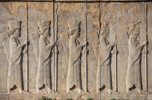 سربازان امپراتوری تاریخی با سلاح در دست سنگ فرش سنگی در شهر باستانی تخت جمشید ایران