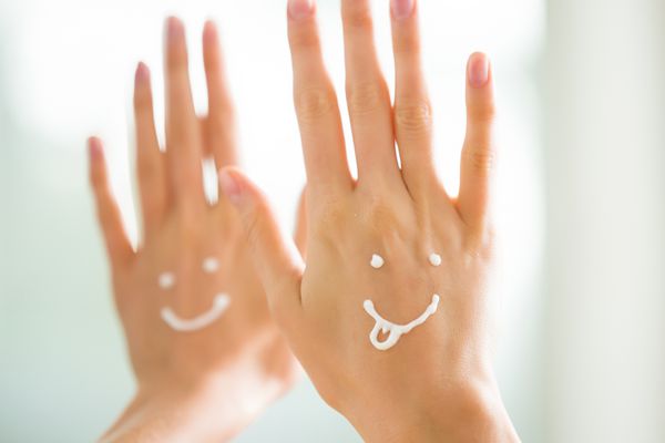 دستهای زیبا و زیبا از انگشتان دست با استفاده از کرم مرطوب کننده و تسکین دهنده پوست چهره های خنده دار خنده دار ایموجی