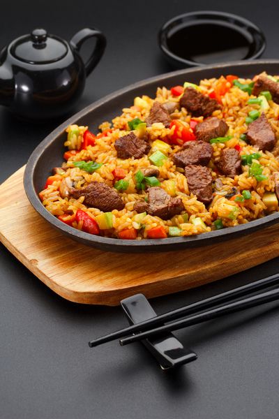 غذای ژاپنی برنج با گوشت گوساله بر روی زمینه سیاه