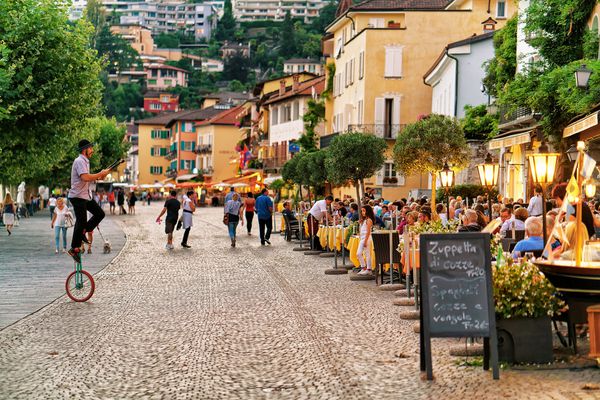 آسکونا سوئیس 23 آگوست 2016 افرادی که در رستوران های خیابانی در شهر Ascona در دریاچه Maggiore در کانتون Ticino سوئیس استراحت می کنند و ناهار می خورند