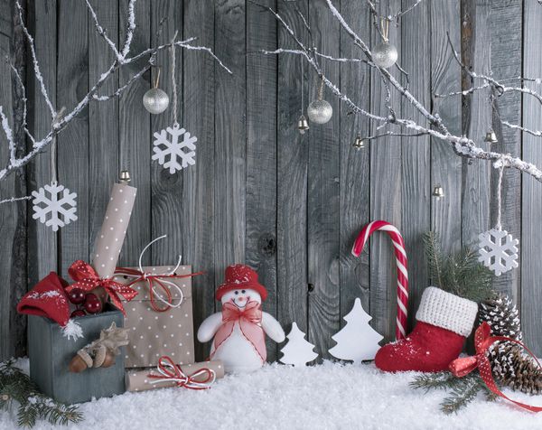 فضای داخلی کریسمس با شاخه های تزئینی هدایا و نیشکر در زمینه تخته های چوبی ترکیب زمستانی سال نو