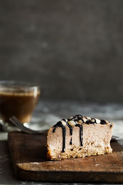 کیک موس شکلاتی خام با آجیل بادام زمینی فندق و لعاب شکلات تیره و قهوه در زمینه چوبی و خاکستری خاکستری دسر بدون قند گلوتن لبنیات کپی کردن فضای عمودی