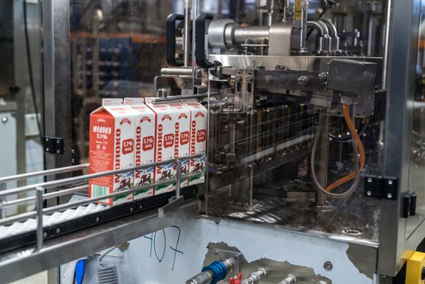 سن پترزبورگ روسیه 16 نوامبر 2016 بسته آزمایش محصولات لبنی روی خط مونتاژ در کارگاه کارخانه ماشین سازی برای تولید دستگاه های بسته بندی
